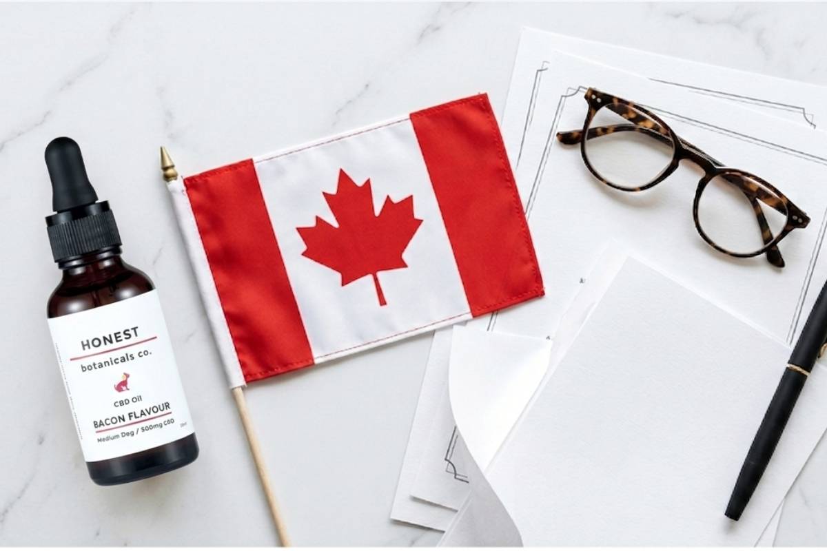 CBD oil bottle next to a drug test specimen cup and clipboard with a maple leaf